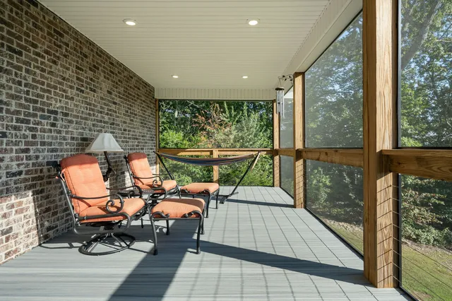 a balcony with chairs and with potted plants