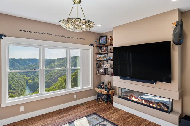 a living room with furniture a flat screen tv and a floor to ceiling window
