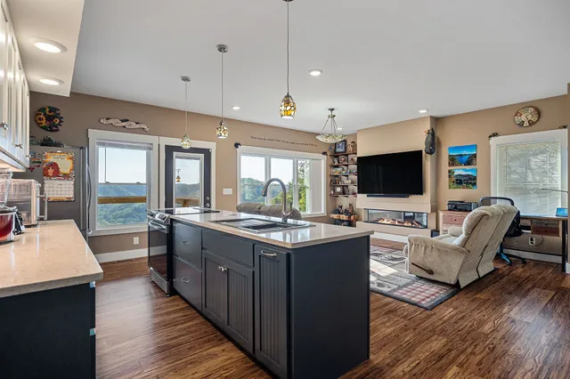 a kitchen with stainless steel appliances granite countertop a sink stove and wooden floor