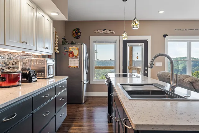 a kitchen with stainless steel appliances granite countertop a stove a sink and a refrigerator