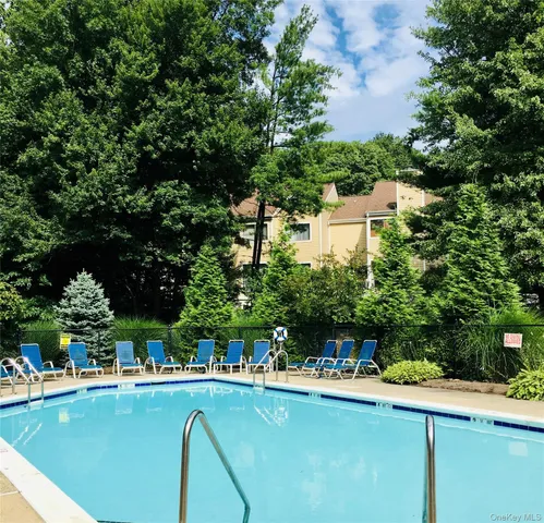 a front view of a house with swimming pool garden and trees