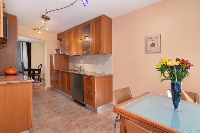 a kitchen with stainless steel appliances kitchen island granite countertop a refrigerator a stove and a sink