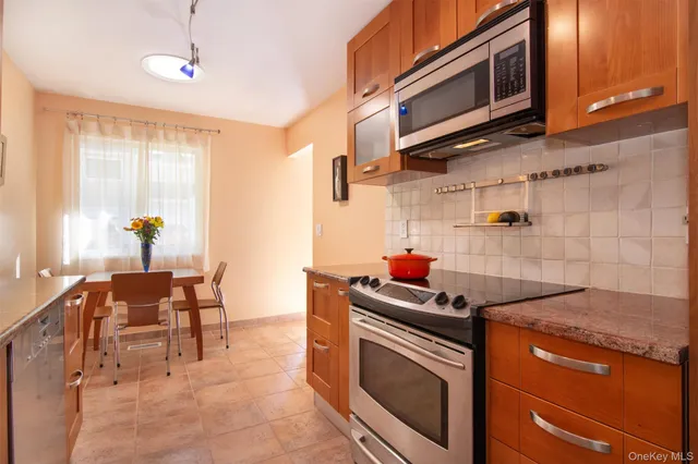 a kitchen with stainless steel appliances granite countertop a stove and a microwave