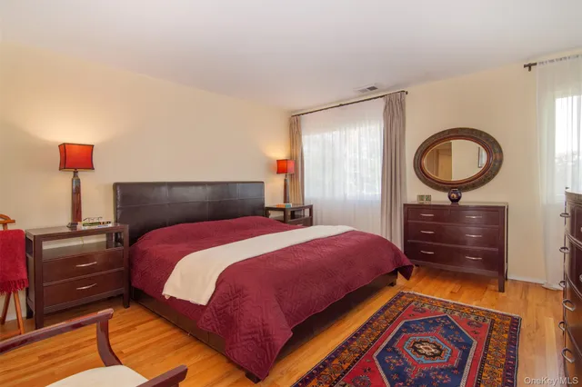 a bedroom with a bed and a lamp on dresser