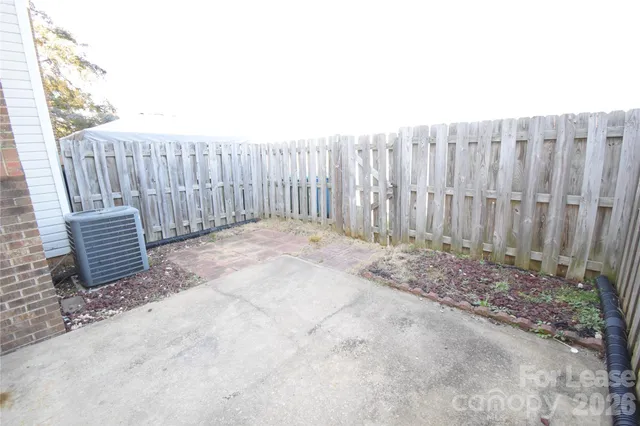 a view of backyard with wooden fence