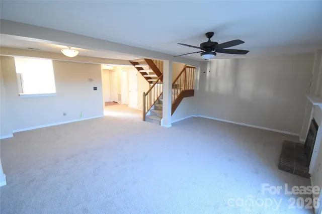 an empty room with windows and ceiling fan
