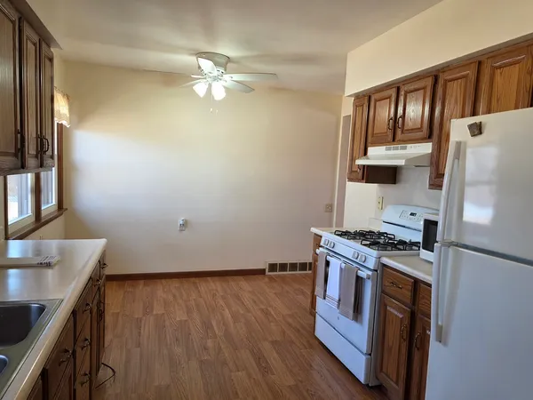 a kitchen with a wooden floor and a stove top oven