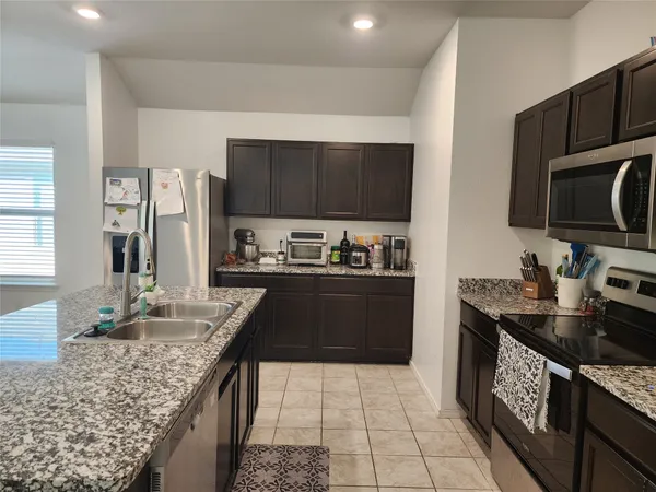 a kitchen with granite countertop a stove and a sink