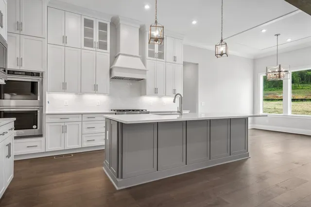 a kitchen with stainless steel appliances kitchen island a white stove top oven and cabinets