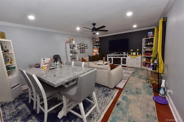 a living room with stainless steel appliances furniture a rug and a flat screen tv