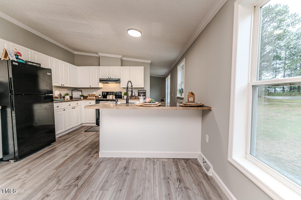2245 Docs Road Lillington, NC 27546 - Photo 39 of 54 a kitchen with kitchen island white cabinets and stainless steel appliances