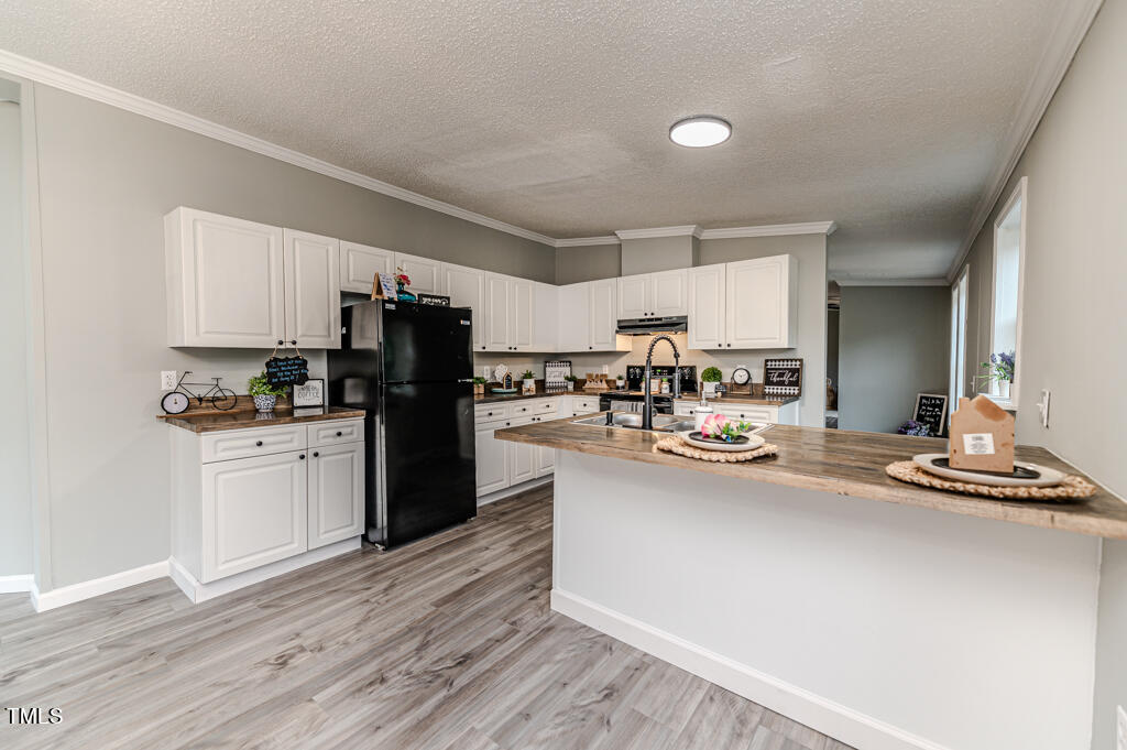 2245 Docs Road Lillington, NC 27546 - Photo 40 of 54 a kitchen with kitchen island white cabinets and stainless steel appliances