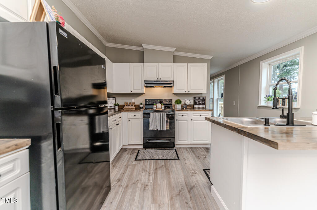 2245 Docs Road Lillington, NC 27546 - Photo 41 of 54 a kitchen with granite countertop wooden floors stainless steel appliances and sink