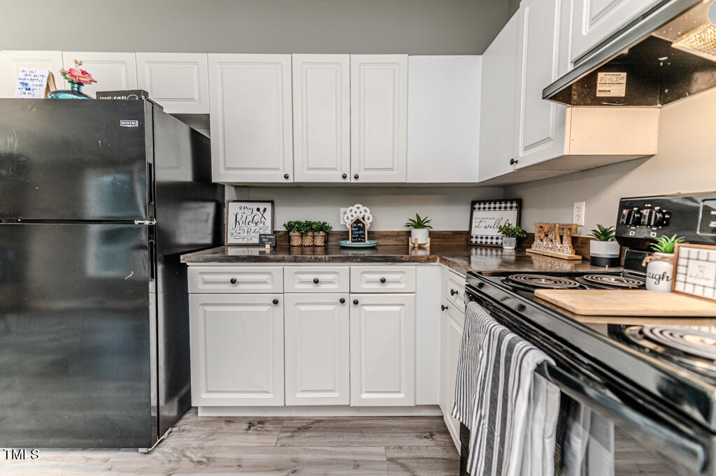 2245 Docs Road Lillington, NC 27546 - Photo 42 of 54 a kitchen with stainless steel appliances granite countertop a refrigerator a sink a stove and white cabinets