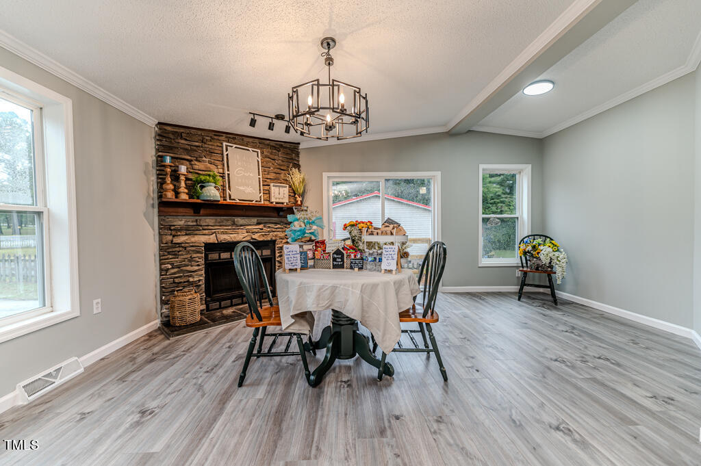 2245 Docs Road Lillington, NC 27546 - Photo 44 of 54 a view of a dining room with furniture a chandelier and wooden floor
