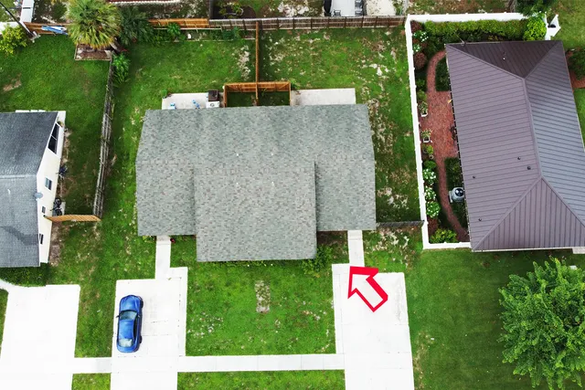 an aerial view of house with swimming pool and yard