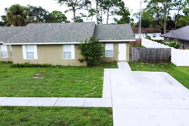 a aerial view of a house with a yard and trees