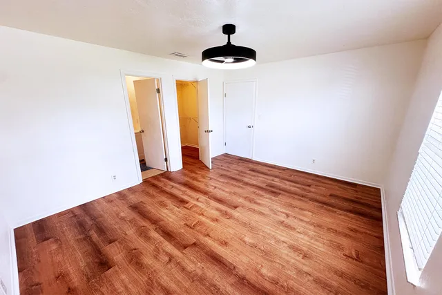 a view of empty room with wooden floor