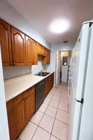 a kitchen with a sink a stove cabinets and a refrigerator