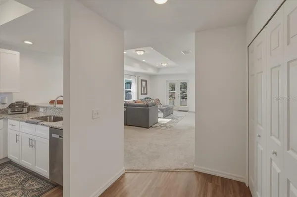 a view of a hallway with wooden floor and a bathroom