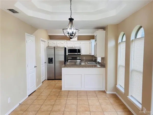 a kitchen with stainless steel appliances granite countertop a refrigerator a stove and a sink