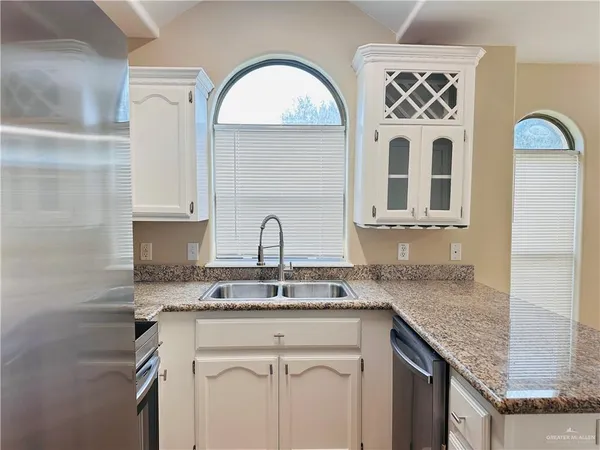 a kitchen with stainless steel appliances granite countertop a sink a stove and cabinets
