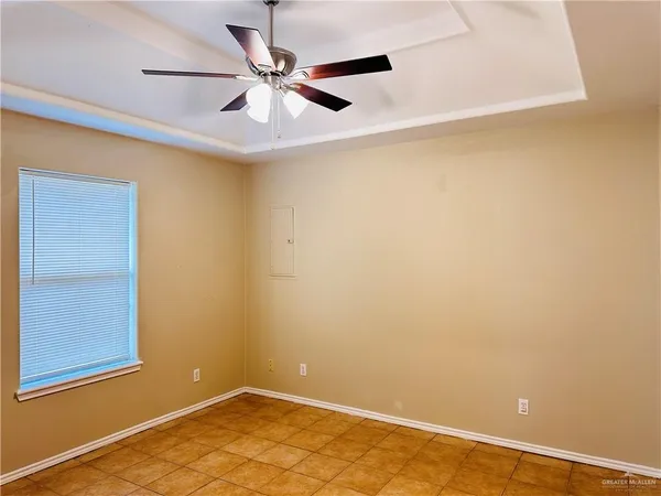 an empty room with a window and a ceiling fan