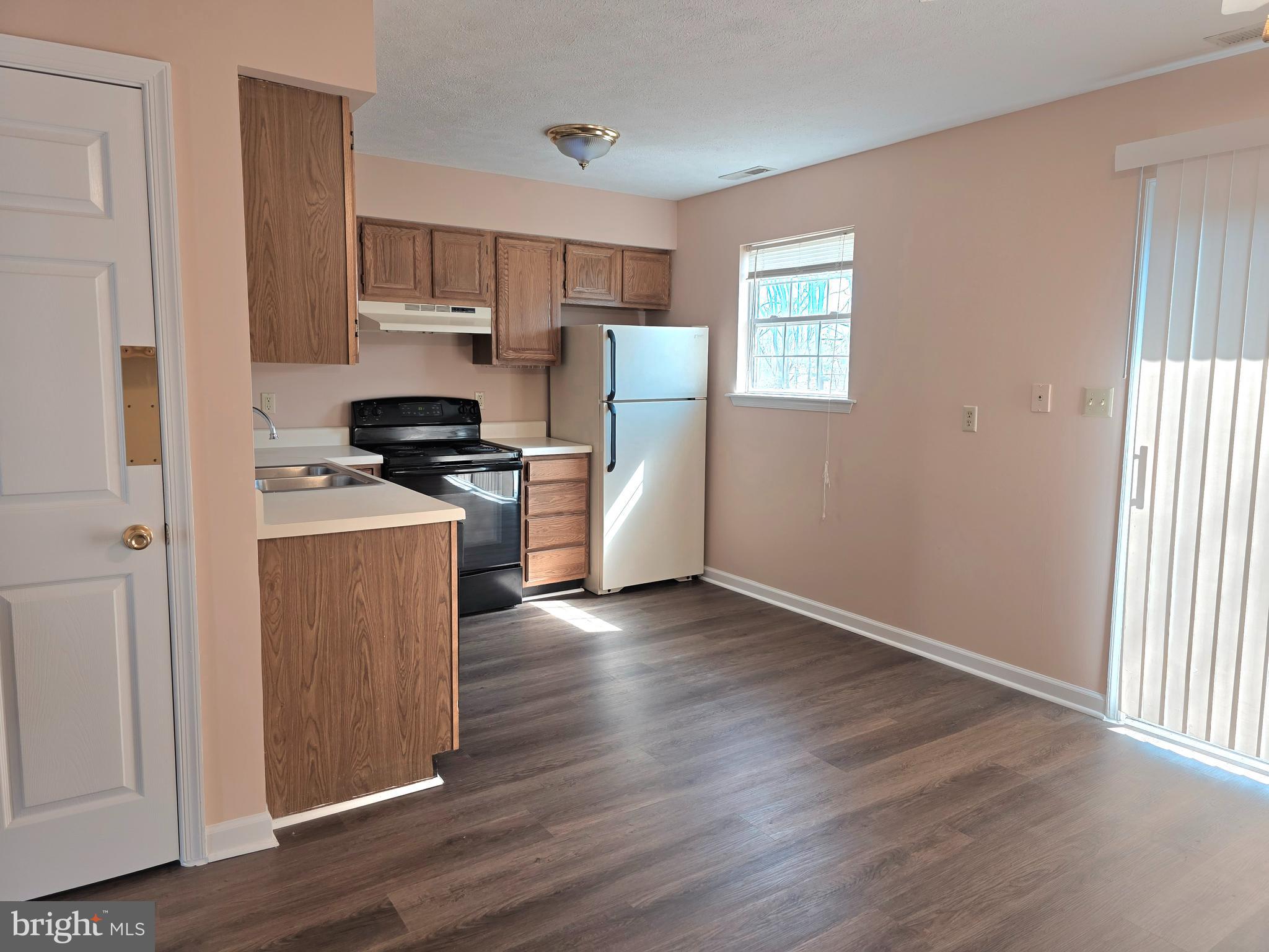 80 Stadium Circle Inwood, WV 25428 - Photo 14 of 53 a kitchen with stainless steel appliances a stove a refrigerator white cabinets and wooden floor