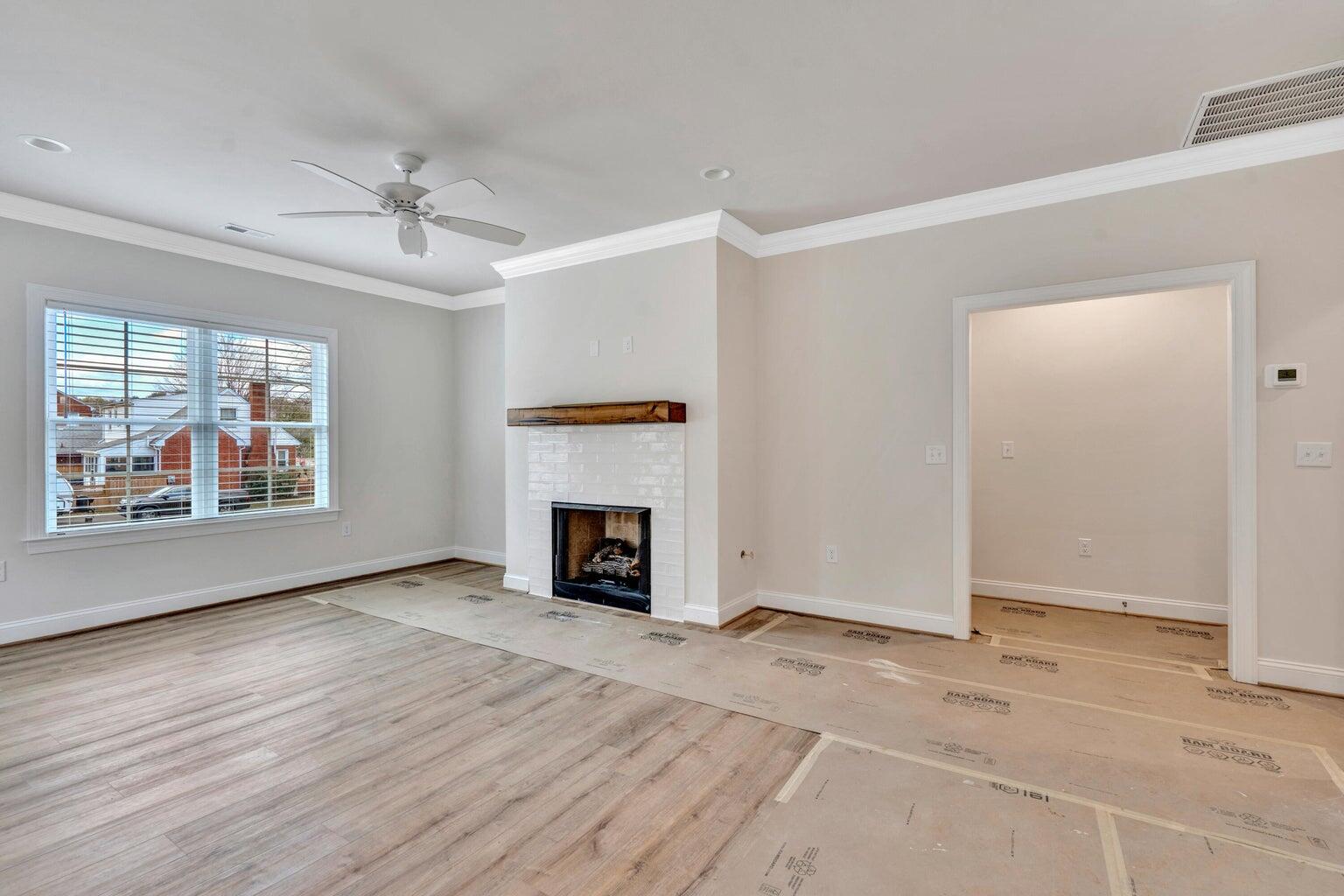 562 Dillard Road Southwest Roanoke, VA 24014 - Photo 4 of 13 an empty room with windows fireplace and fans