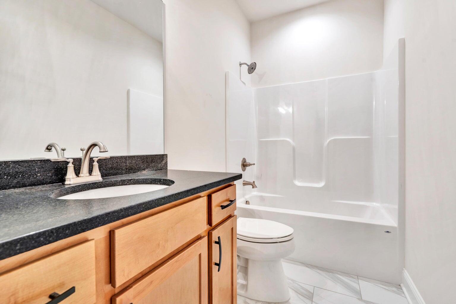 562 Dillard Road Southwest Roanoke, VA 24014 - Photo 10 of 13 a bathroom with a granite countertop sink a toilet and bathtub