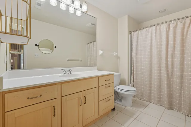 a bathroom with a double vanity sink mirror and toilet