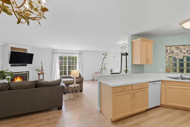 a living room with furniture a flat screen tv and kitchen view