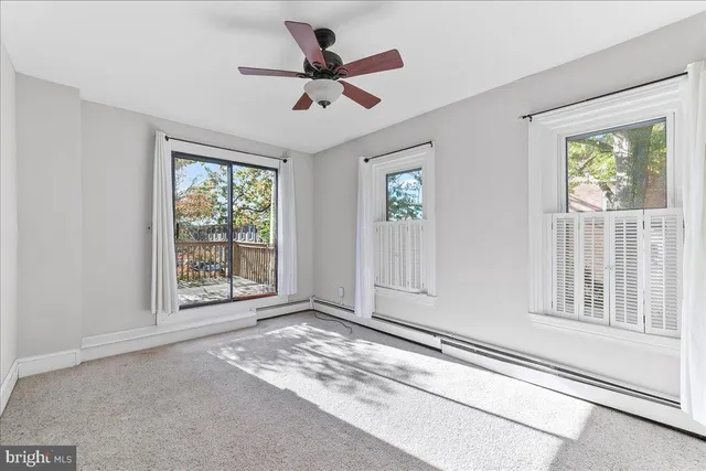 an empty room with fan and windows