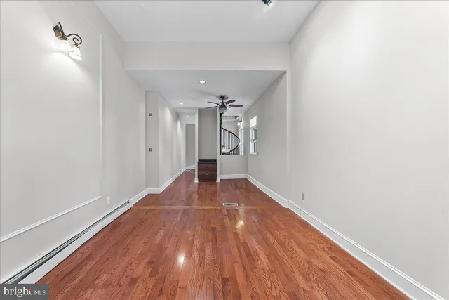 a view of empty room with wooden floor