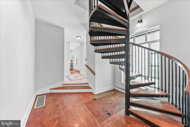 a view of staircase with white walls and a potted plant