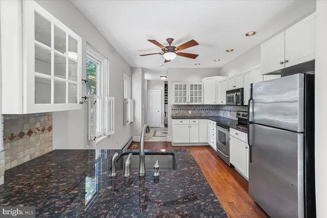 a kitchen with kitchen island a counter top space a sink appliances and cabinets
