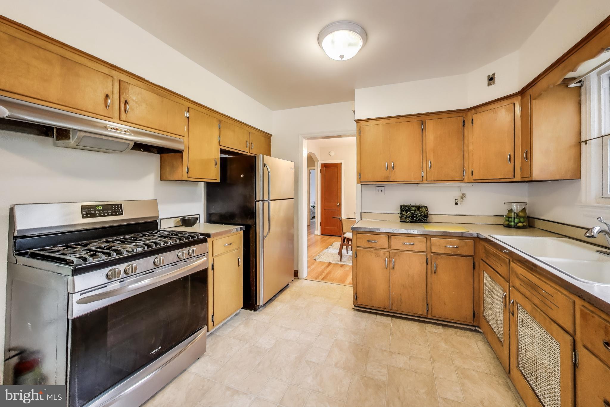 4401 32nd Street Mount Rainier, MD 20712 - Photo 8 of 38 a kitchen with stainless steel appliances granite countertop a stove a sink and a refrigerator