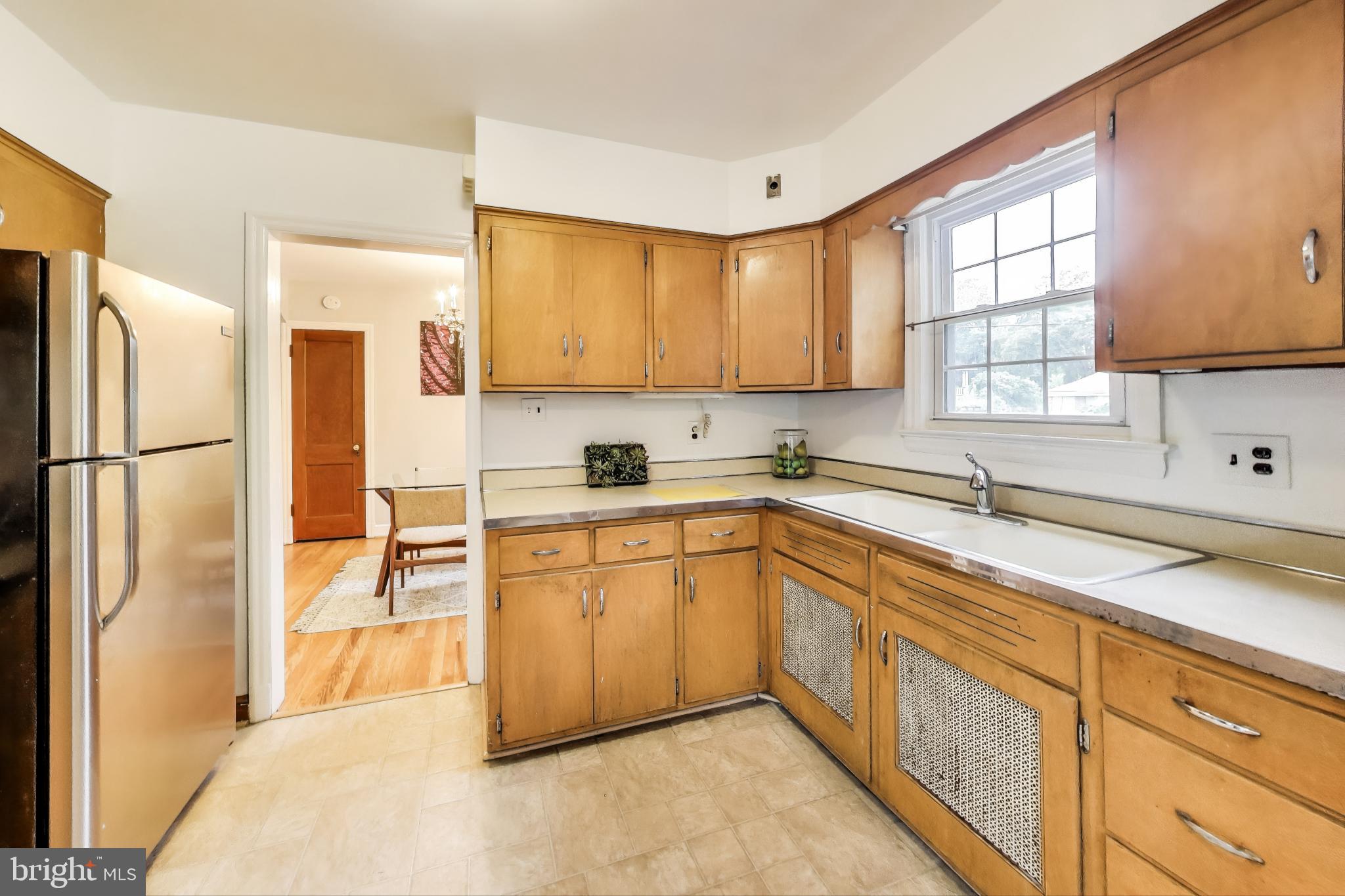 4401 32nd Street Mount Rainier, MD 20712 - Photo 9 of 38 a kitchen with stainless steel appliances granite countertop a refrigerator sink and white cabinets