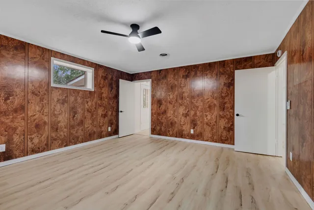 a view of an empty room with wooden floor