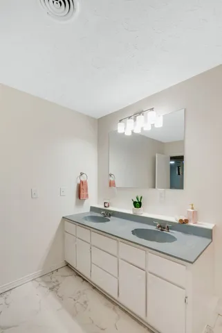 a bathroom with a granite countertop sink and a mirror