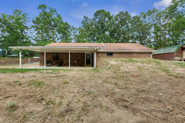 a view of house with backyard and seating area