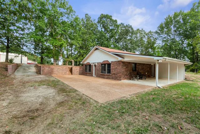 a view of a house with a yard and large tree