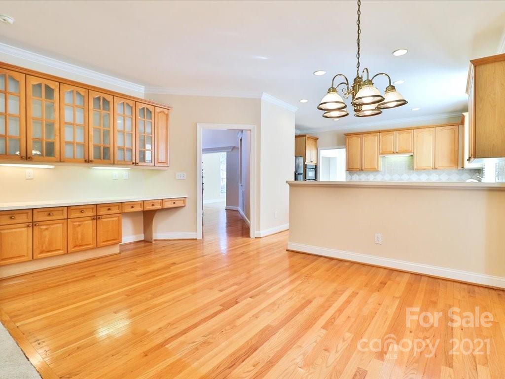 3426 Rhett Butler Place Charlotte, NC 28270 - Photo 13 of 40 a view of an empty room with kitchen and wooden floor