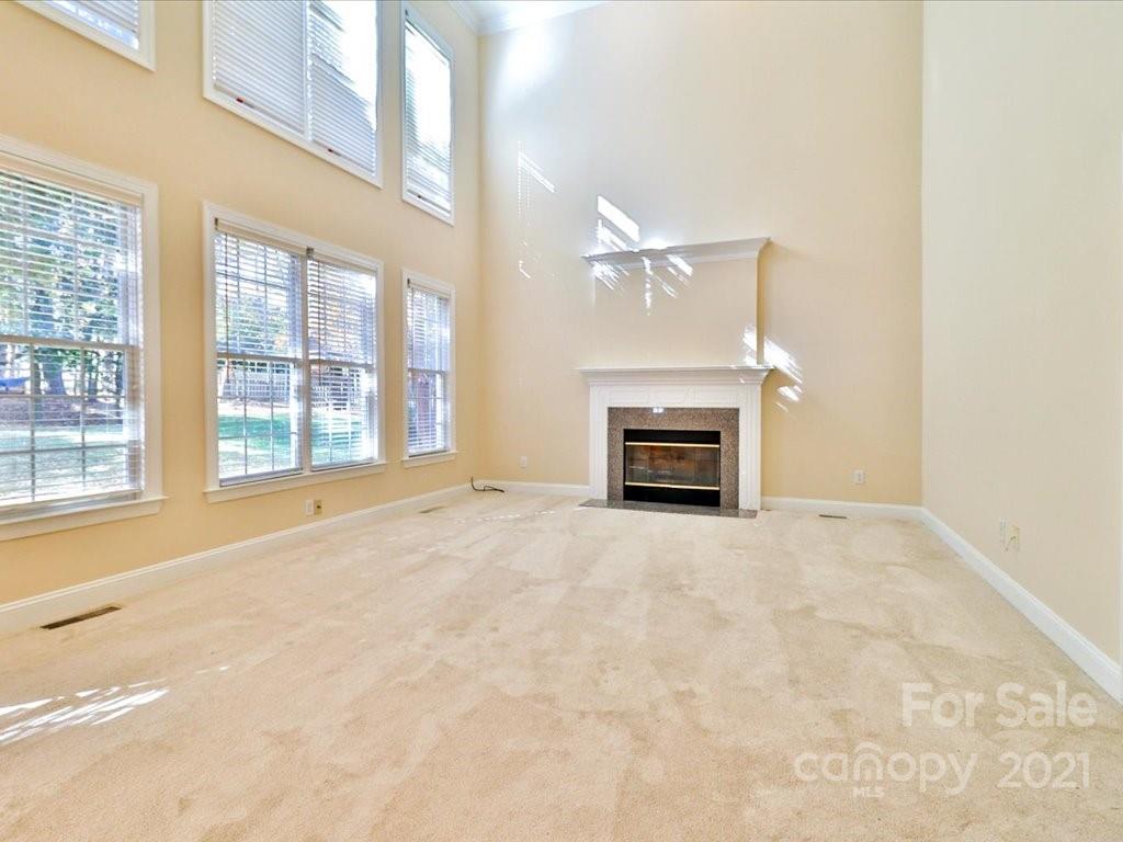3426 Rhett Butler Place Charlotte, NC 28270 - Photo 17 of 40 en empty room with a fireplace and windows