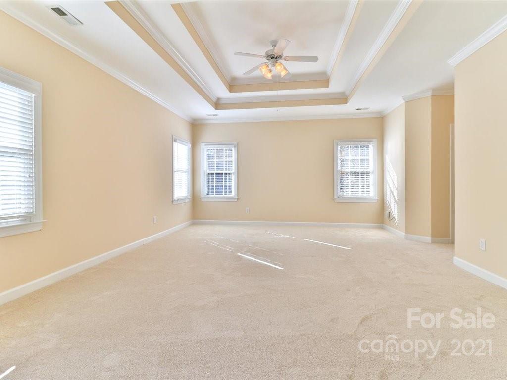 3426 Rhett Butler Place Charlotte, NC 28270 - Photo 24 of 40 en empty room with windows and chandelier fan