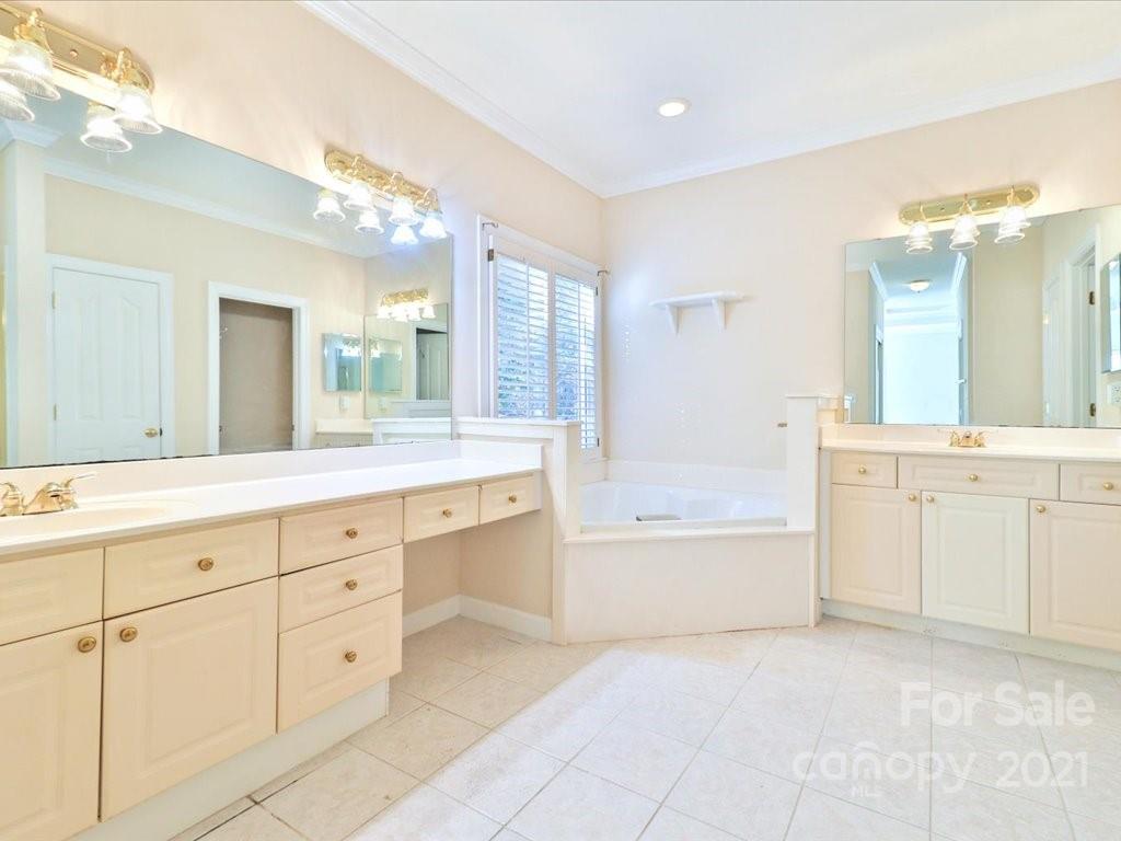 3426 Rhett Butler Place Charlotte, NC 28270 - Photo 27 of 40 a spacious bathroom with a granite countertop sink a mirror a bathtub and next to a window