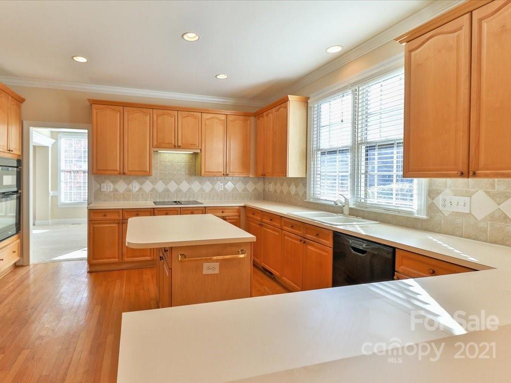 3426 Rhett Butler Place Charlotte, NC 28270 - Photo 9 of 40 a kitchen with stainless steel appliances granite countertop a sink and cabinets with wooden floor