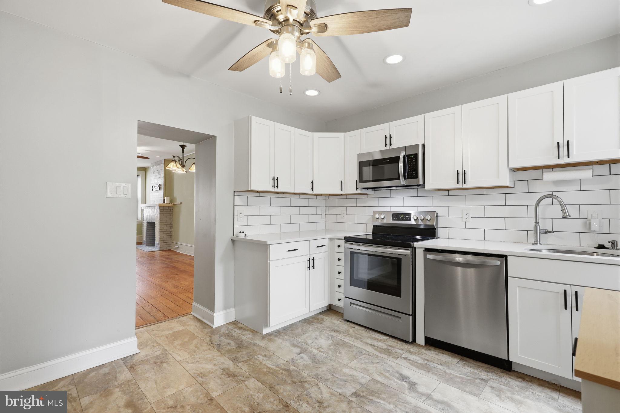 353 Hermitage Street Philadelphia, PA 19128 - Photo 12 of 31 a kitchen with stainless steel appliances granite countertop a stove top oven a sink and dishwasher