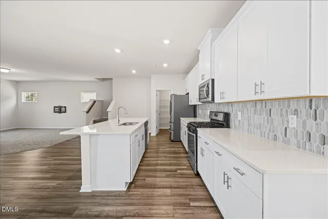 a large white kitchen with sink stove and refrigerator