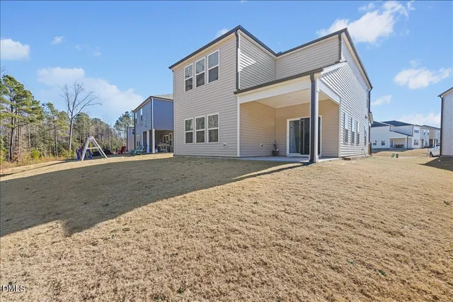 a view of a house with backyard and parking